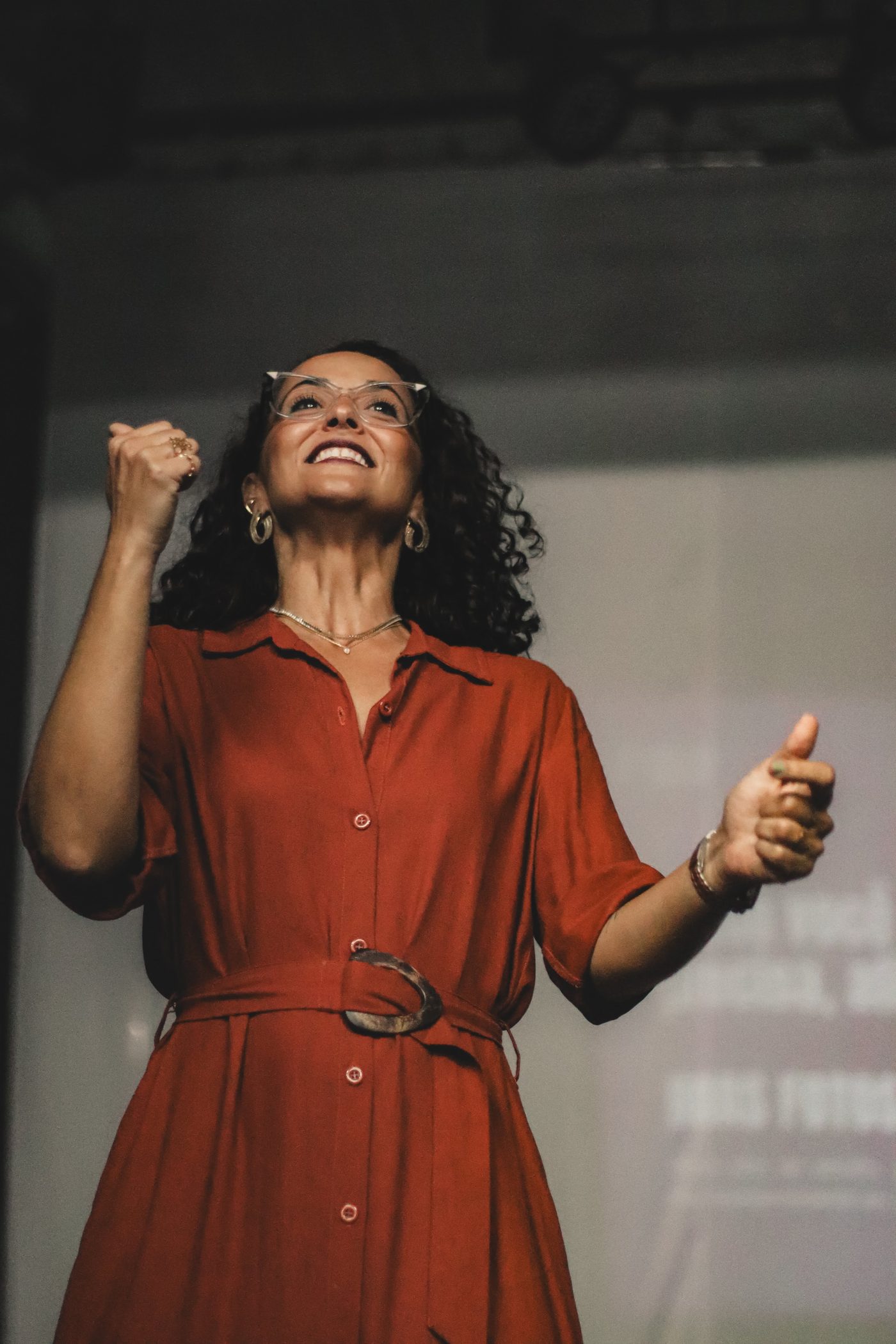 Luana Trindade sorri de punho erguido durante a palestra Saúde Mental